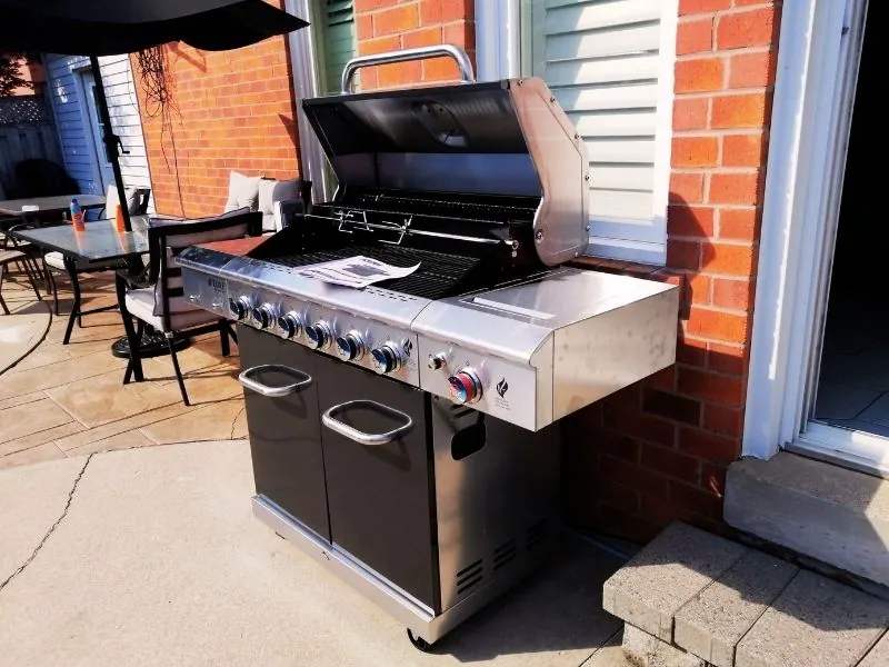 Charcoal grill assembled beside a poolside patio