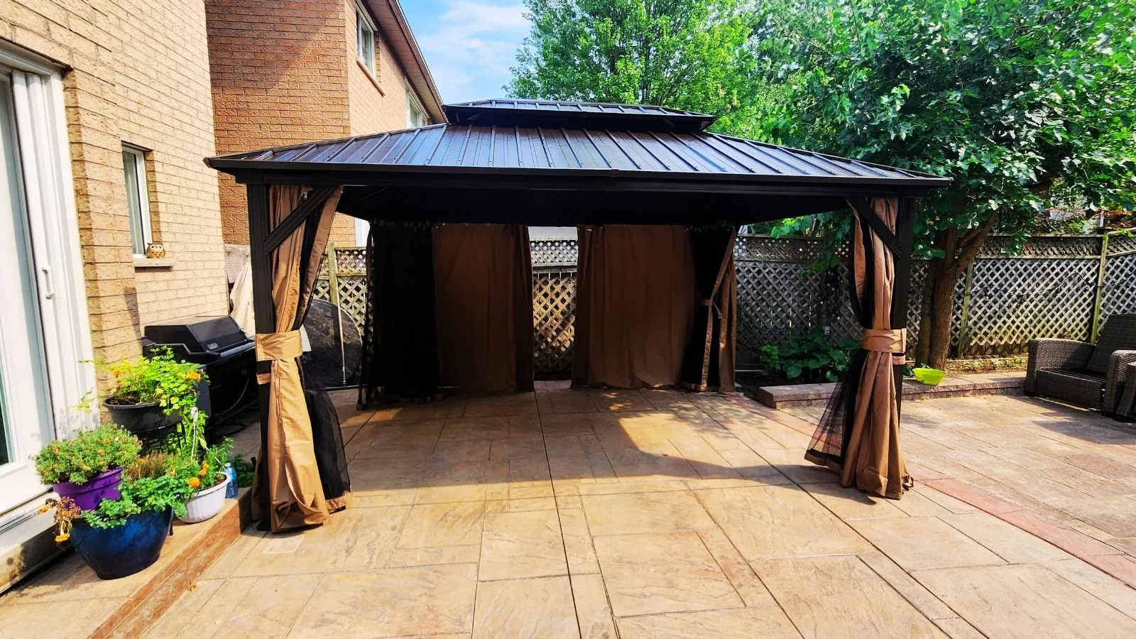 Hardtop gazebo assembled and anchored on a stone patio in the GTA
