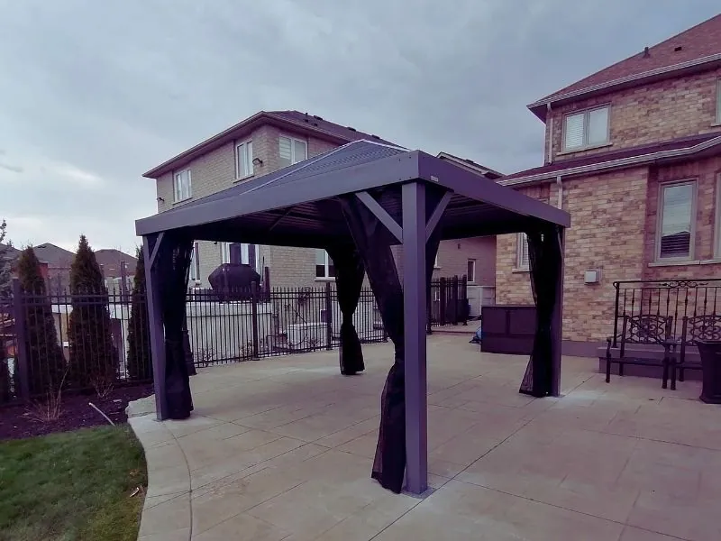Hardtop gazebo assembled and anchored on a stone patio in the GTA