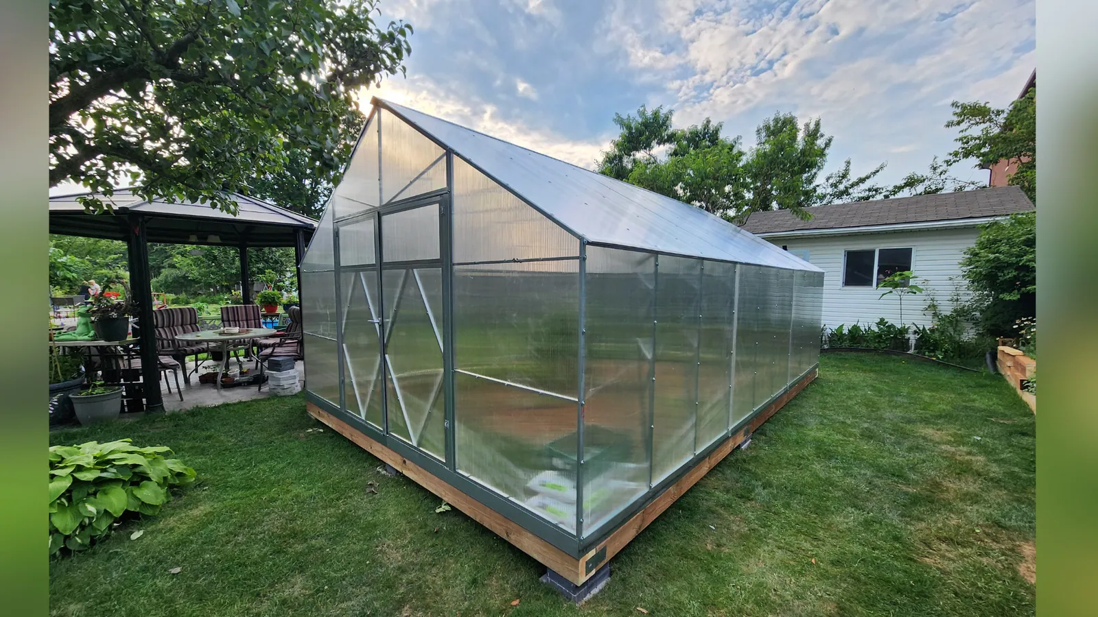 Polycarbonate greenhouse assembled and anchored on a levelled base