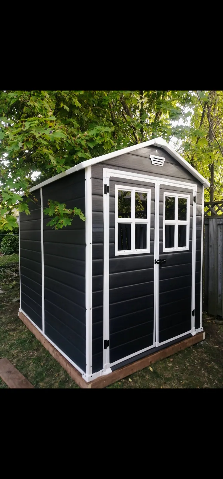 Resin storage shed assembled level in a backyard