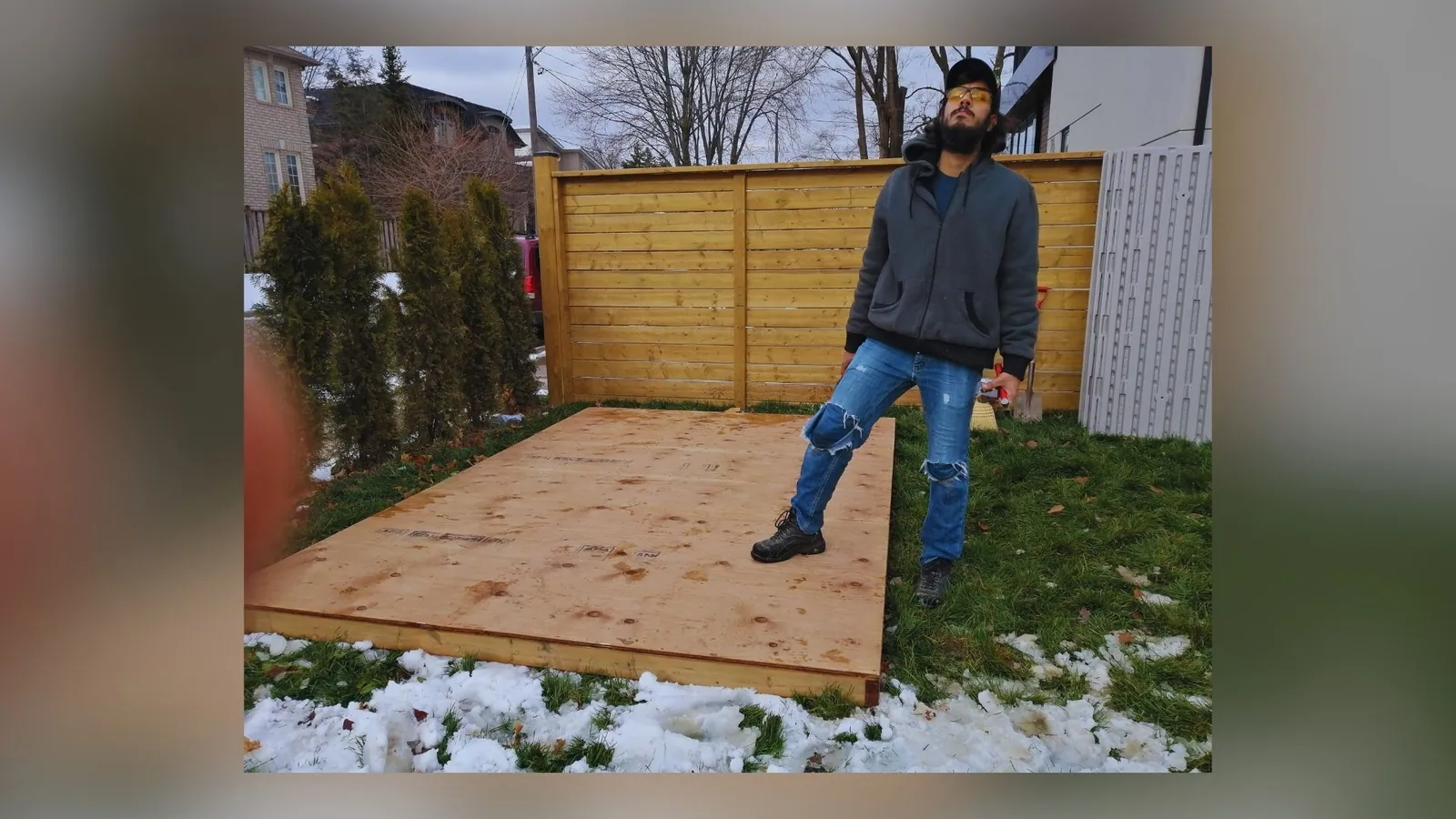 Installers building a shed wall panel in a backyard