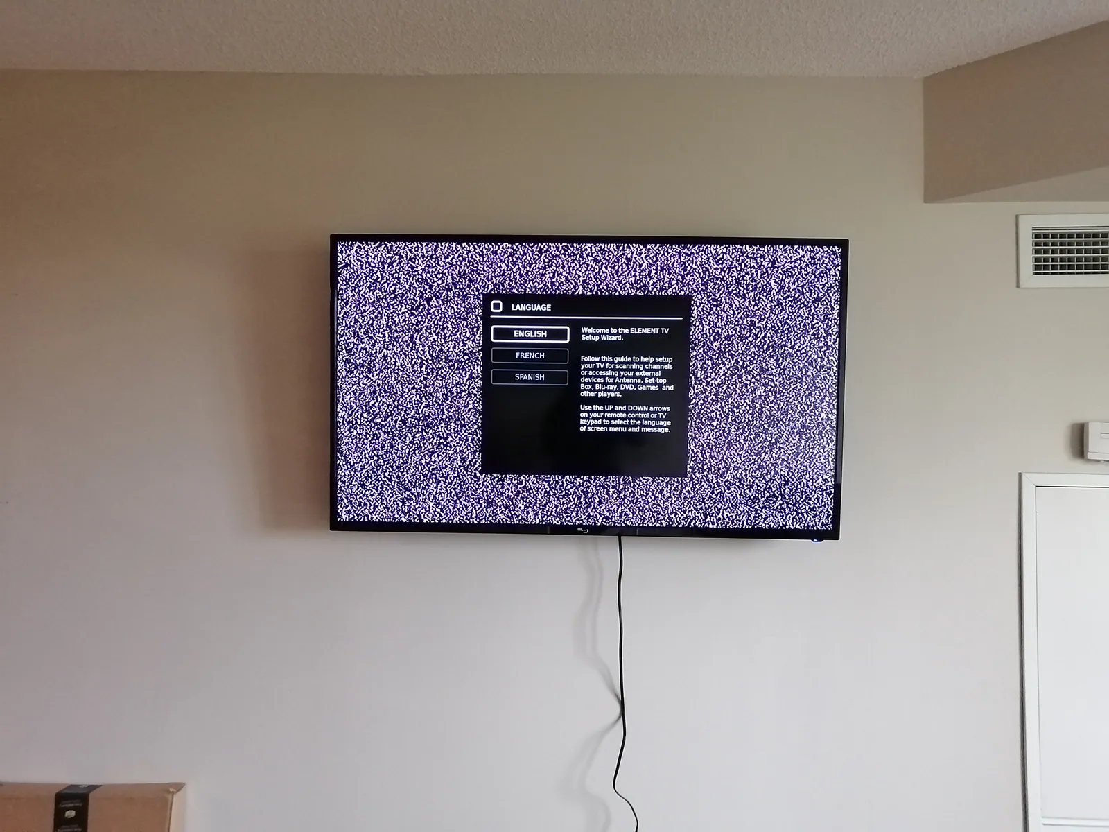 Television wall mounted above a fireplace with cables concealed