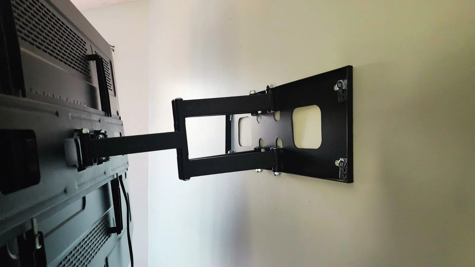 Television wall mounted above a fireplace with cables concealed